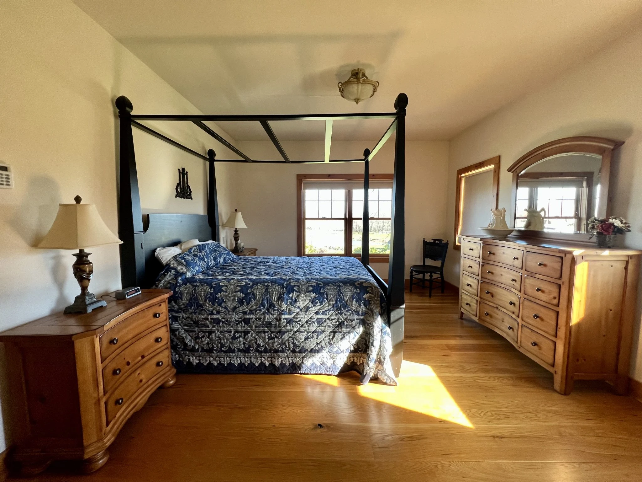 sun filled room in farm house with canopy bed